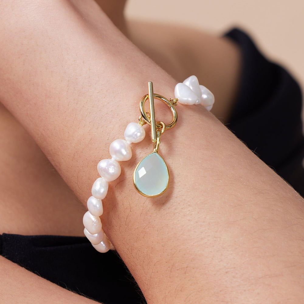 
                  
                    Clara white irregular cultured freshwater pearl bracelet with an aqua chalcedony drop pendant
                  
                