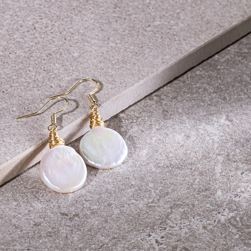 
                  
                    Credo coin pearl earrings set in gold wirework
                  
                