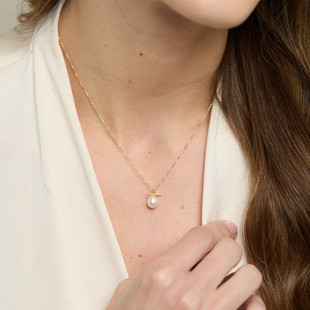 
                  
                    Gratia gold plated sterling silver chain with central white cultured freshwater pearl beneath delicate bar
                  
                