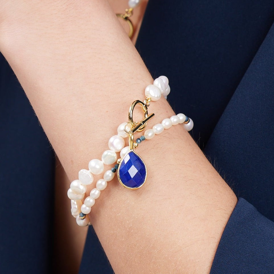 
                  
                    Clara white irregular cultured freshwater pearl bracelet with a lapis lazuli drop pendant
                  
                