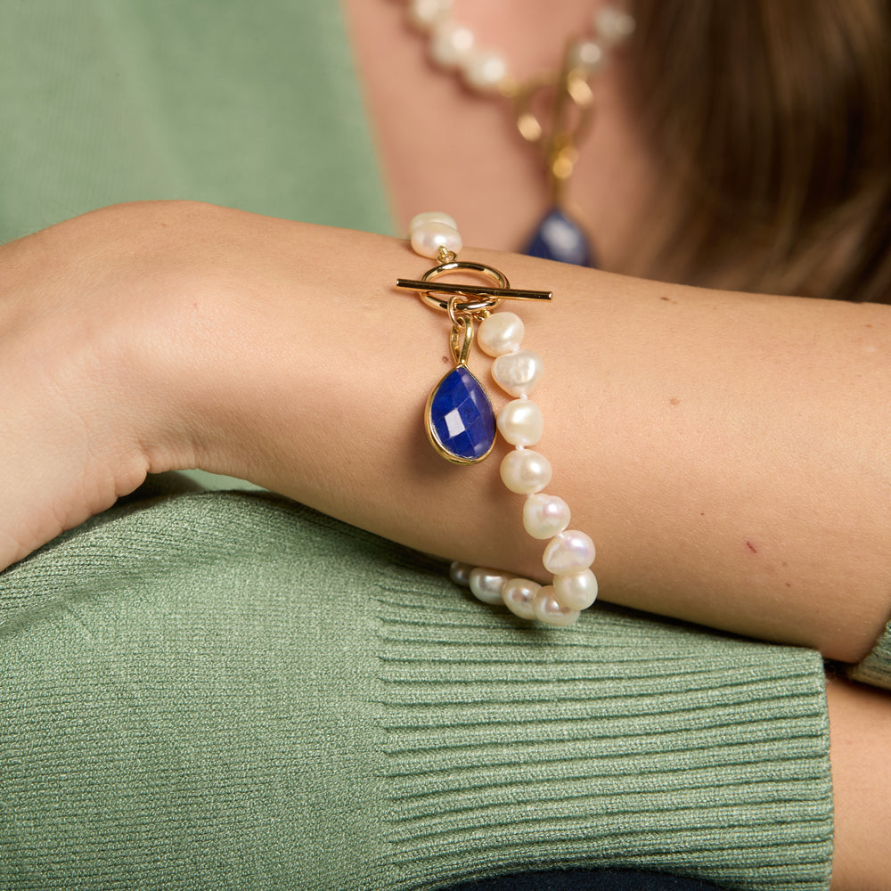 
                  
                    Clara white irregular cultured freshwater pearl bracelet with a lapis lazuli drop pendant
                  
                