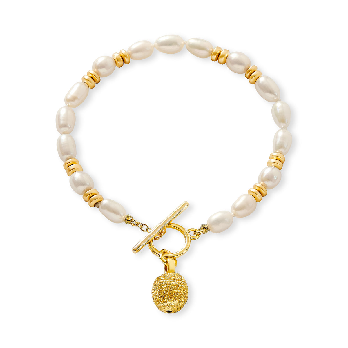 Delicate white oval cultured freshwater pearl bracelet with small gold hematite beads and ribbed gold vermeil ball charm hanging from gold plate over copper toggle clasp