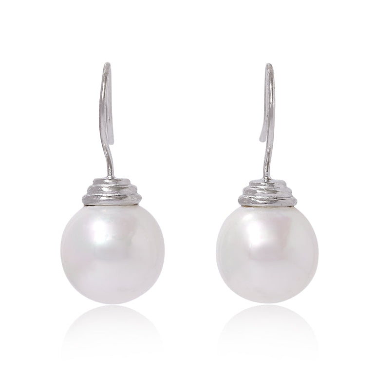 Pair of large round mother of pearl earrings with silver hooks on a white background