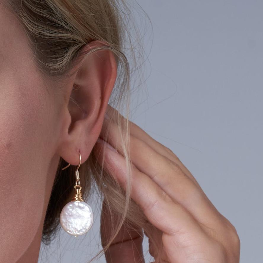 
                  
                    Credo coin pearl earrings set in gold wirework
                  
                